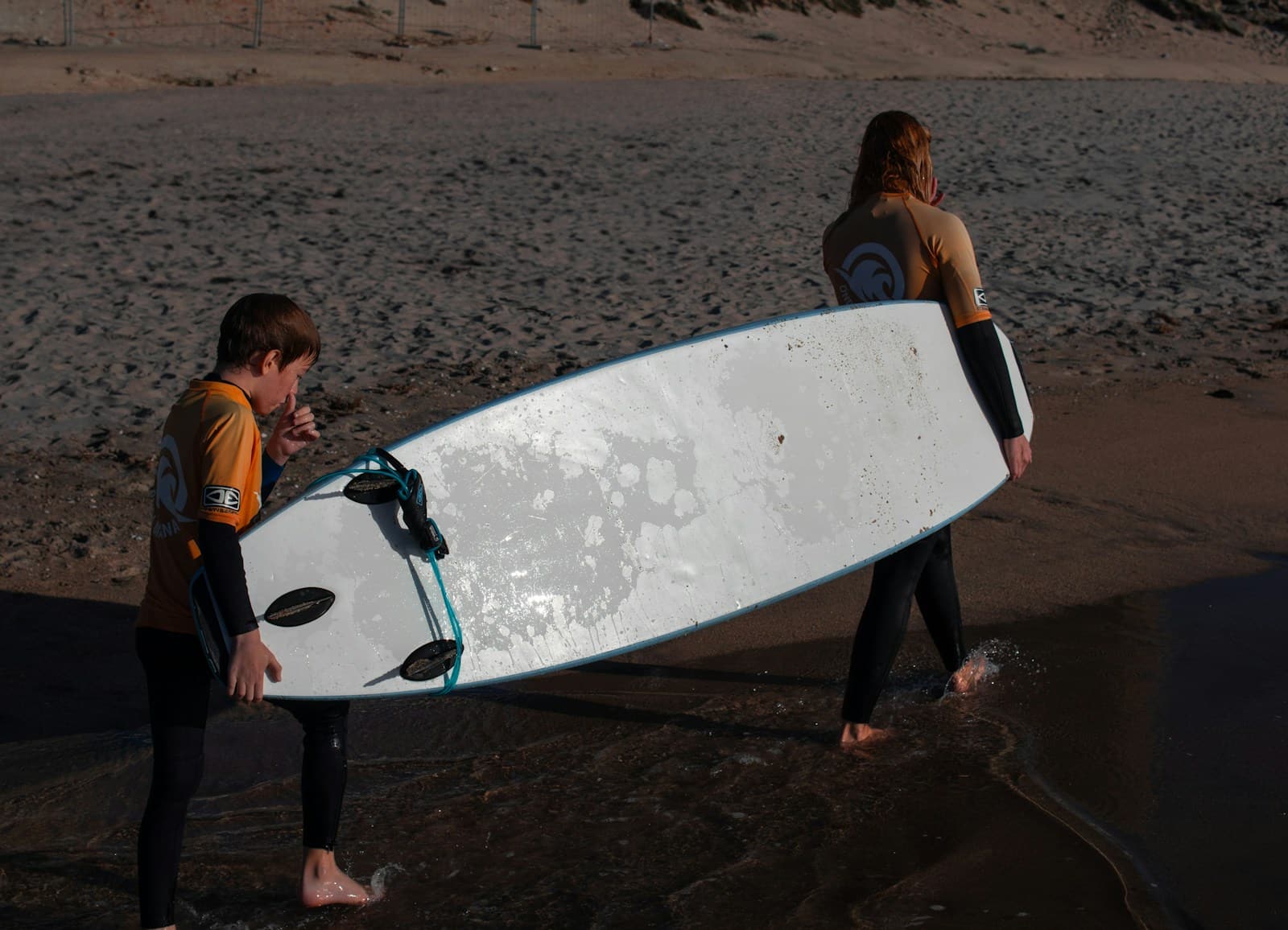 A couple of people that are holding a surfboard